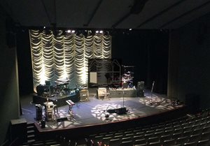 View of the auditorium stage from the back-left seating section.